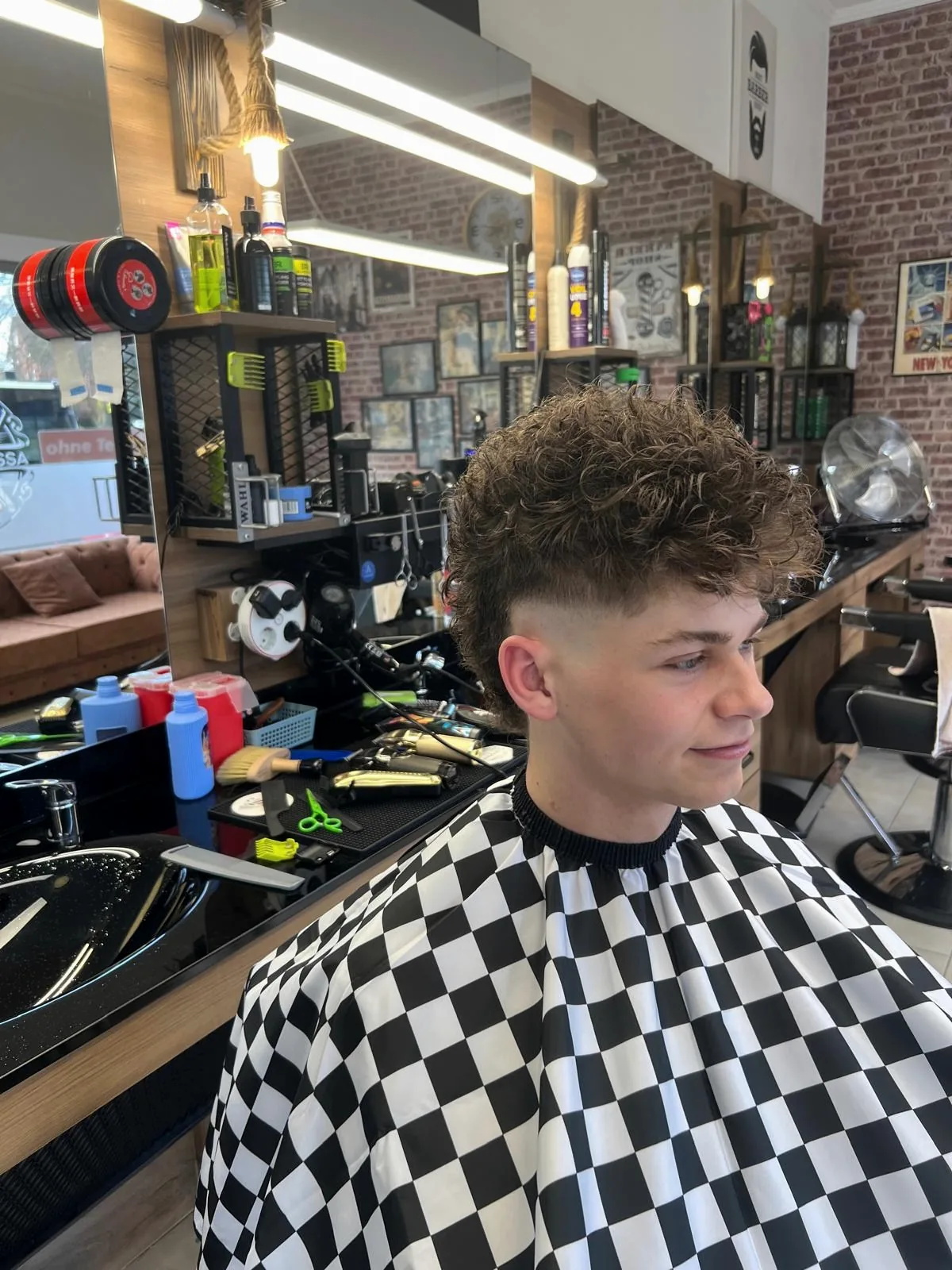 Seitliches Porträt mit lockigem Deckhaar und Fade